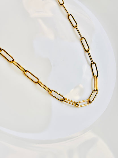 Gold chain necklace on a white plate