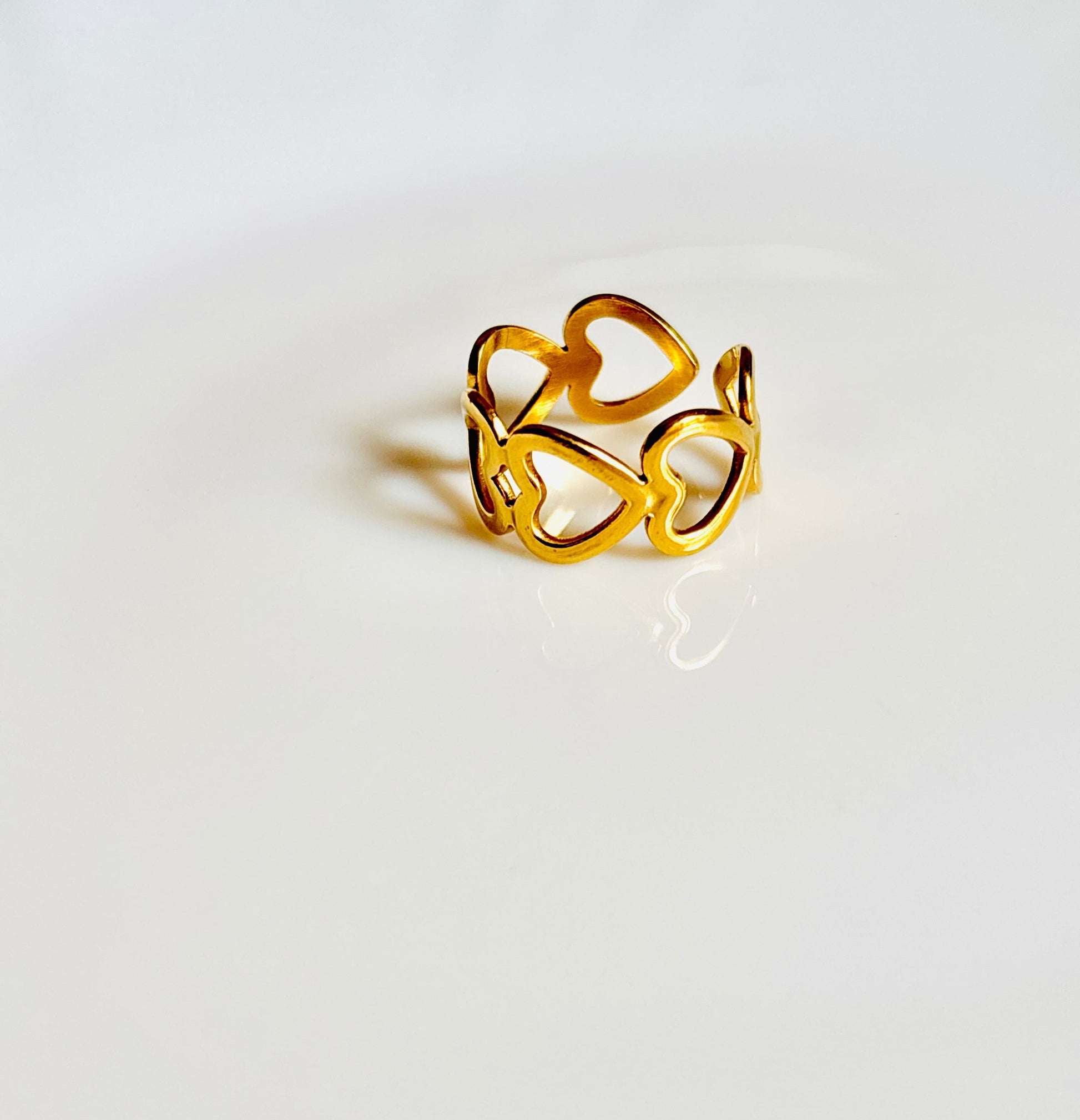 Gold ring with a heart design on a white surface